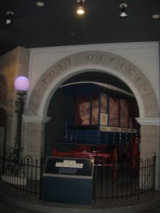 Wagon filled with package under stone arch reading Post Office.